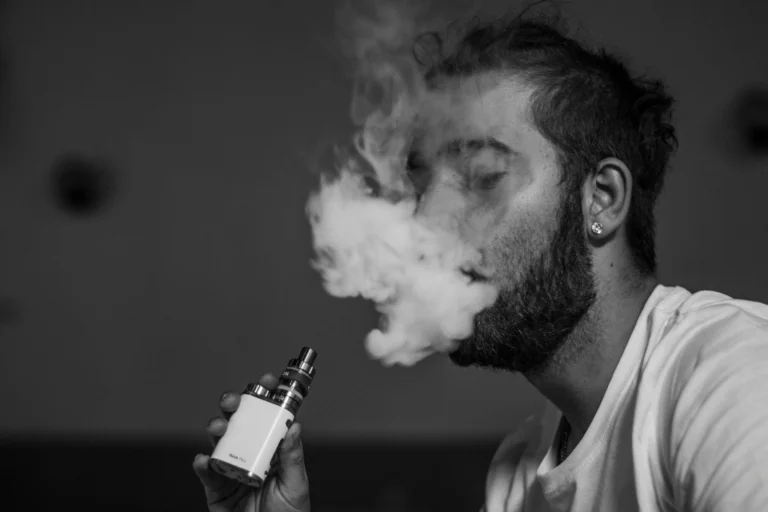 男子使用電子煙吐出煙霧，搭配日本梵茶鐵觀音煙油風味解析文章